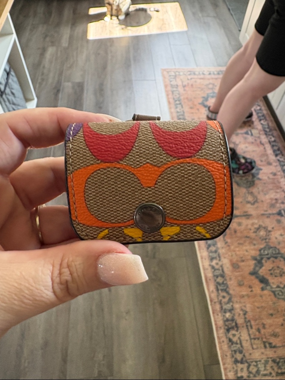 Coach Mini Snap Pouch in Brown with Orange, Red & Yellow Signature Print.